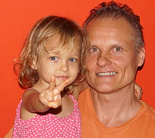 Jamie, the owner of International Introductions a renown marriage agency in South America and his young daughter who is giving the peace sign