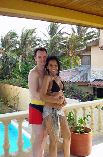 Young American man and Colombian woman holding each other and smiling