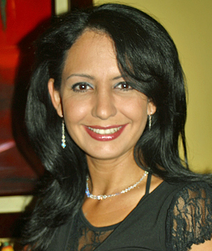 Mature Colombian Woman Smiling A mature Colombian woman with black hair, wearing a black lace dress and jewelry, smiling warmly representing profiles from 40 years and older