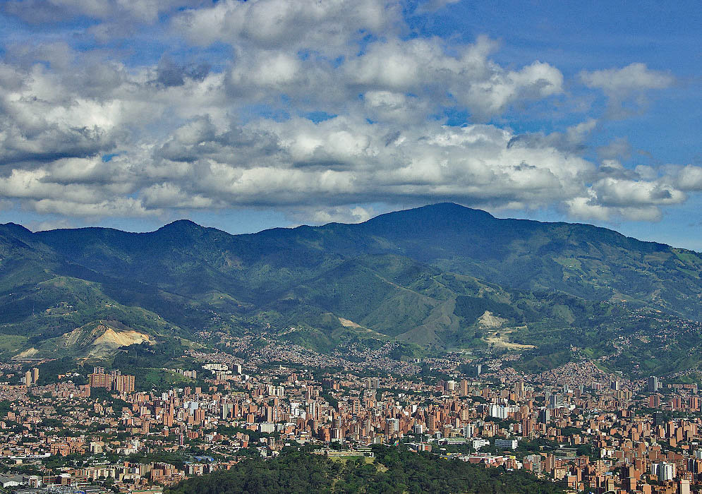 A vista of congested Medellin and tall green mountains in the background