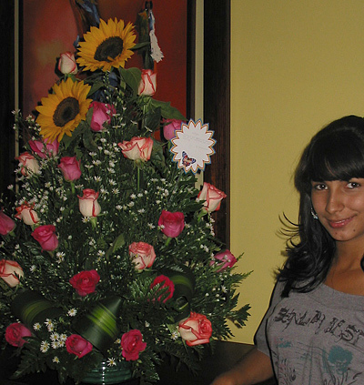 Tropical Flowers Gift A Colombian woman receiving beautiful flowers, fruits, chocolate, teddy bear and wine as a gift