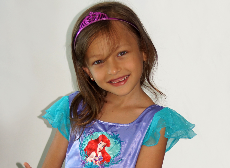 A child beaming in her Disney purple princesses costume