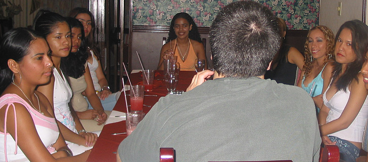 A small group of Colombian women meeting one man during a romance tour at a restaurant