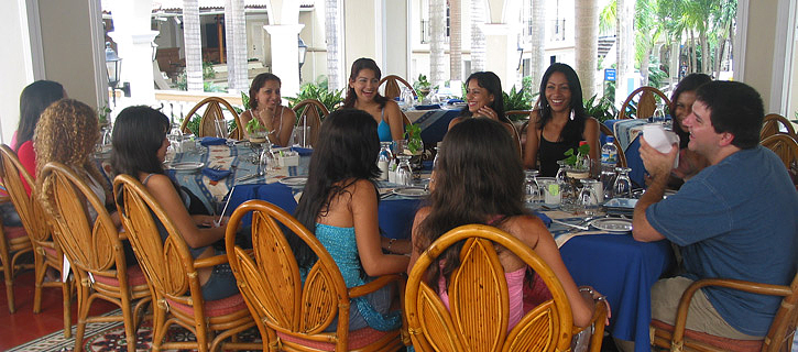 A small group of Latin women meeting one man during a romance tour at an outdoor restaurant