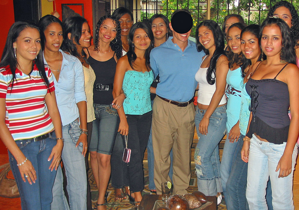 One man in the center of 13 women all smiling after Romance Tour introduction