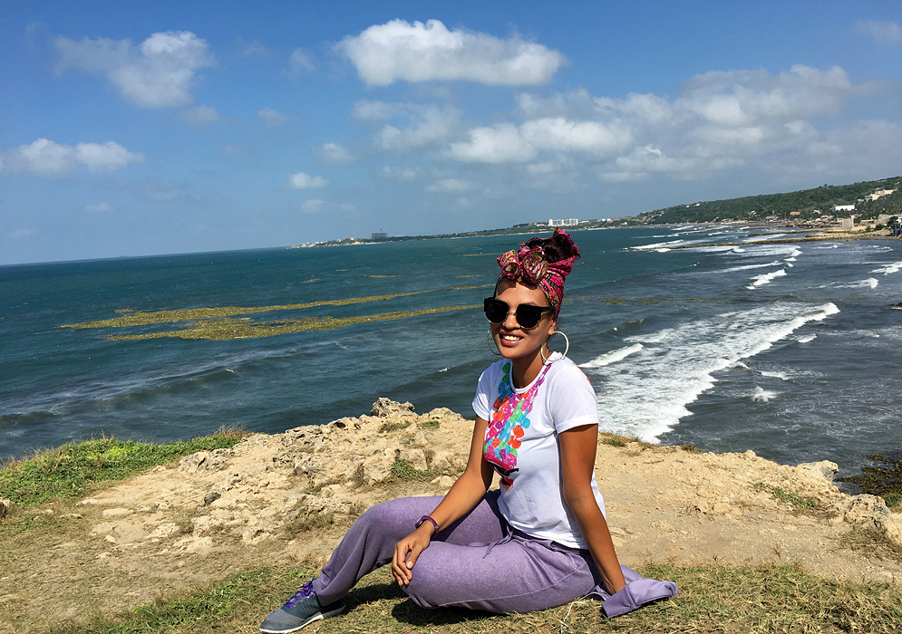 Salgar Coastline An attractive Colombian woman sitting on a cliff overlooking the ocean near Barranquilla on a clear sunny day