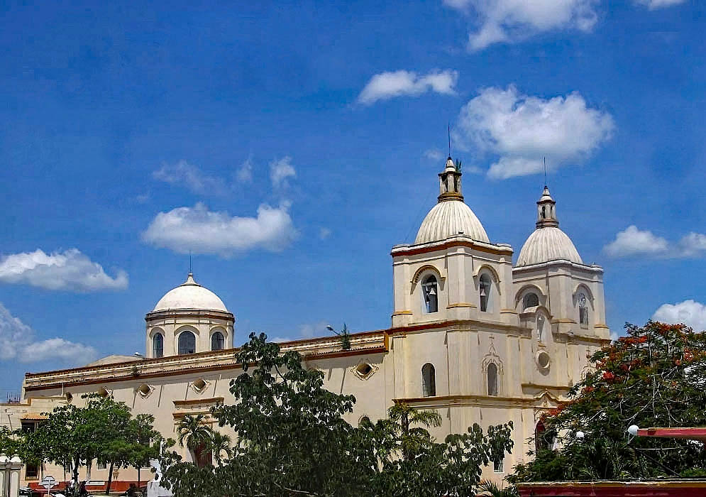Side angle of church with blue sky and white clouds