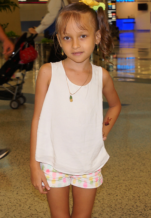 A lovely young girl wearing a white blouse and shorts