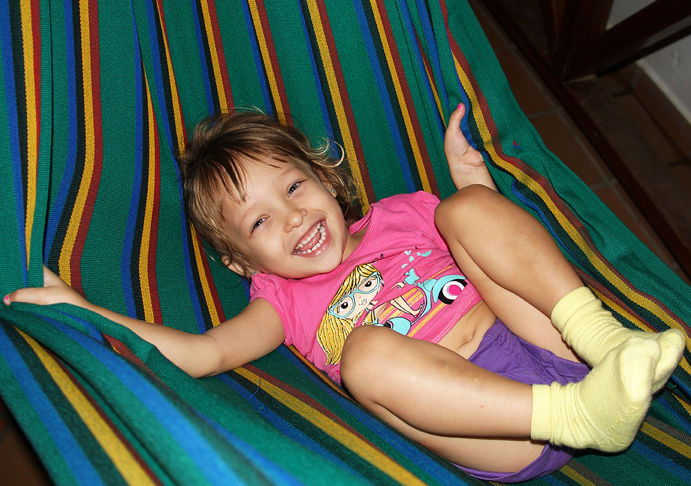 Toddler swings happily on a hammock