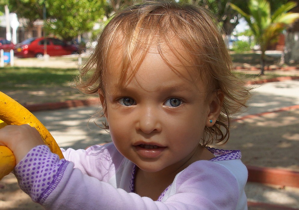 A toddler sweaty from playing in the playground