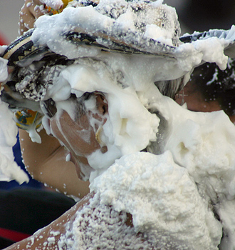 Carnival spectators covered in white foam