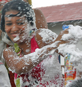 Carnival spectators covered in white foam